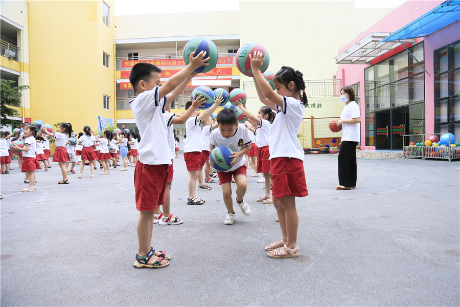 广西-东盟经开区直属幼儿园老师在室外指导孩子们进行体育锻炼