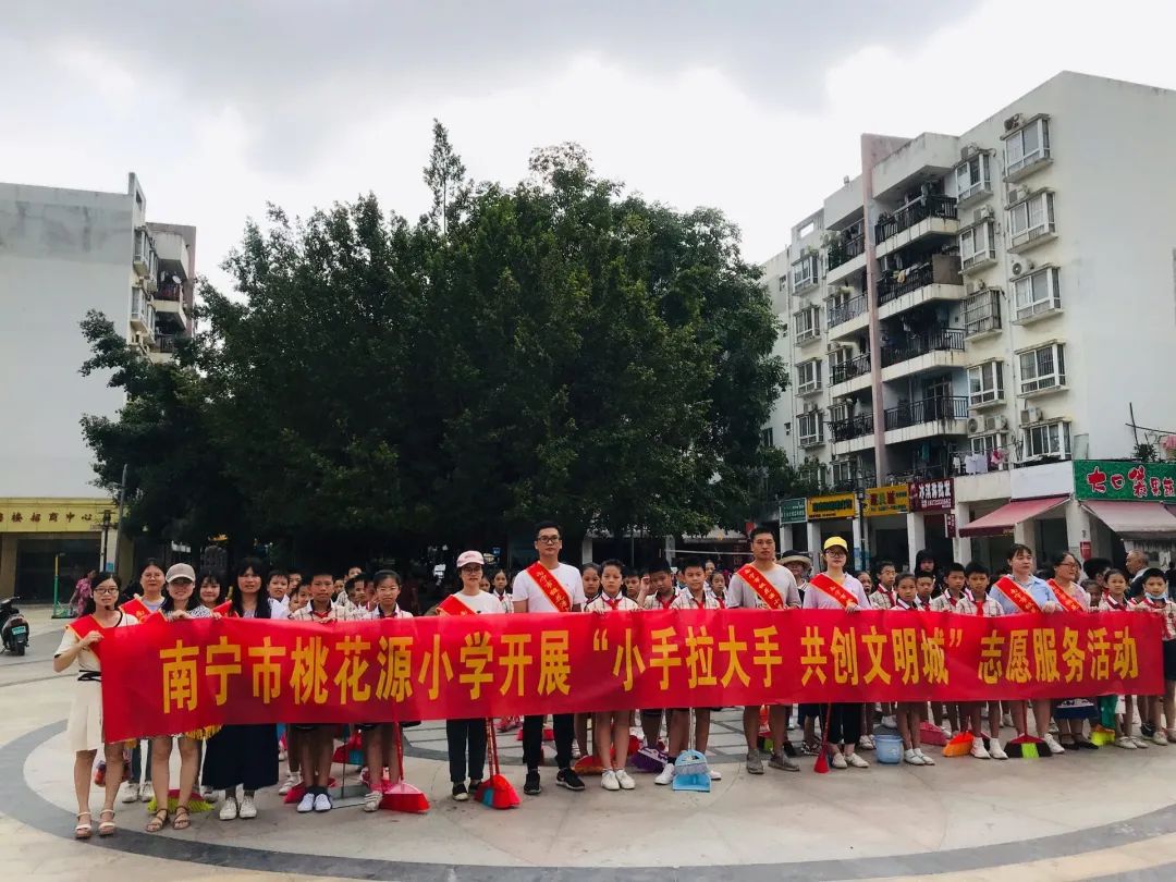 桃花源小学师生和家长们在桃花源社区开展"小手拉大手, 共创文明城"