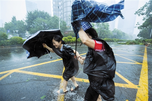 在深圳市南山区科技园,行人在风雨中前行